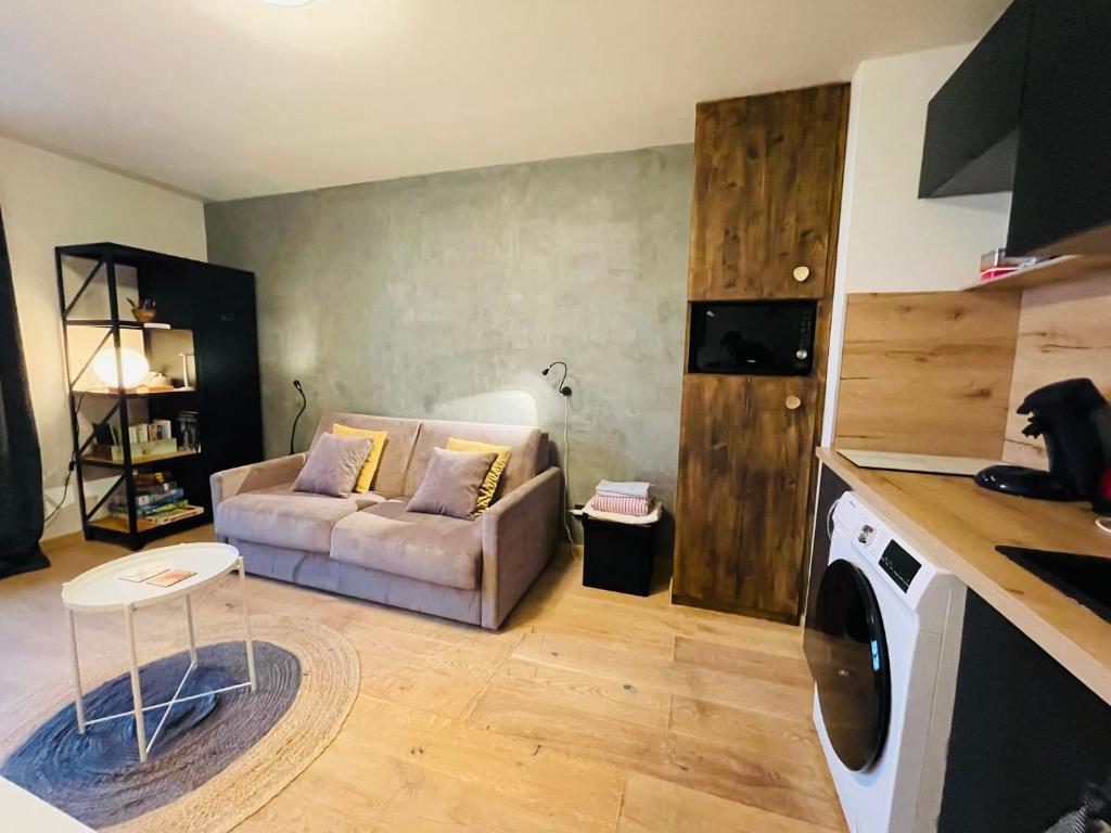 a living room with a couch and a table and a kitchen at Le Chaplin face au lac Léman in Évian-les-Bains
