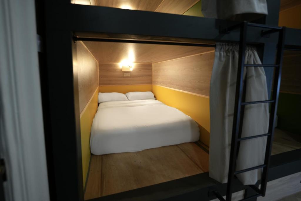a small bed in a bunk bed room with a ladder at Revolver Edinburgh in Edinburgh