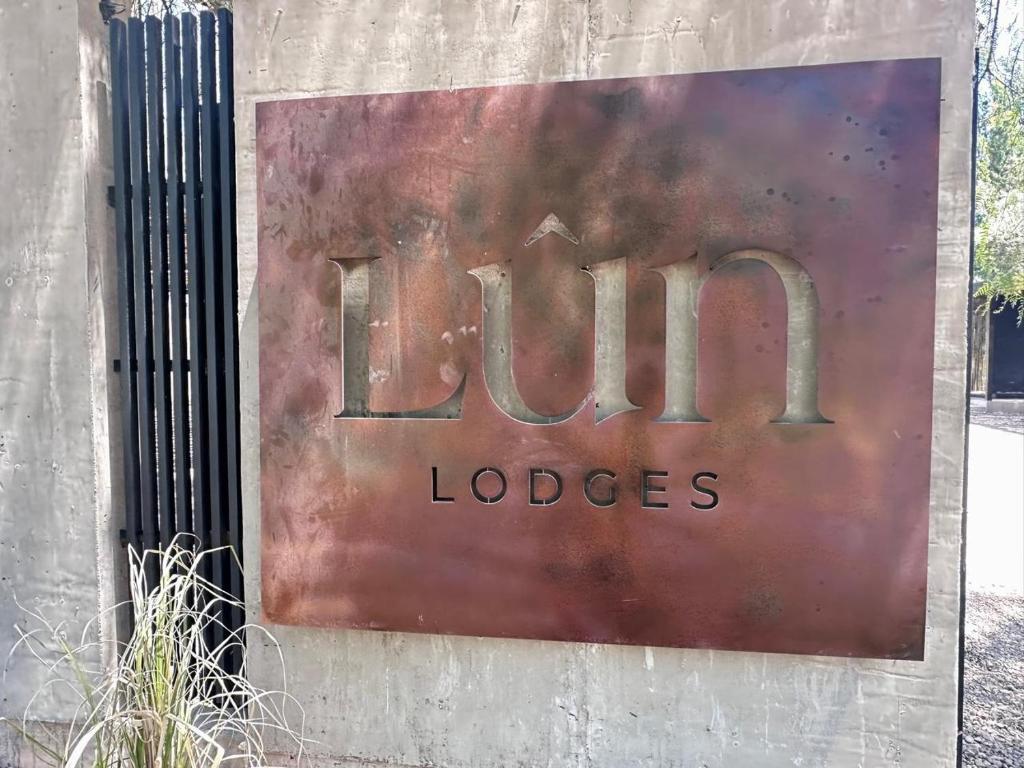a sign on a wall that reads lions lodges at LÜN Lodges in Chacras de Coria