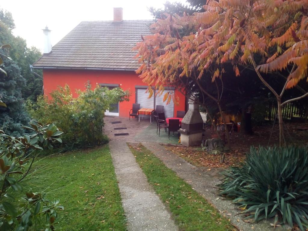 ein rotes Haus mit einem Tisch und Stühlen davor in der Unterkunft Rita Vendégszobák in Sopron