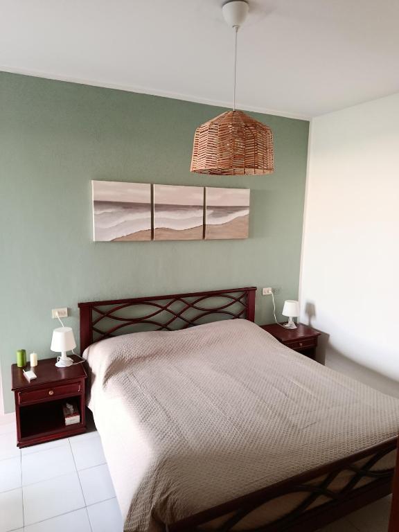 a bedroom with a bed with two night stands and two lamps at Casa nel parco 3 camere 2 bagni 6 ospiti in Luni
