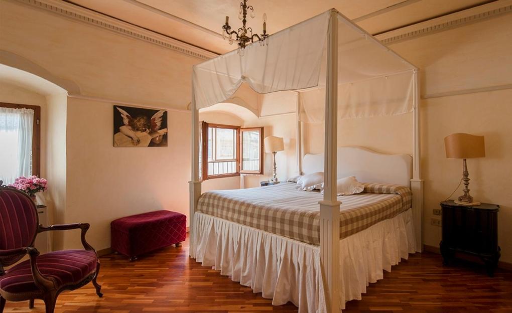 フィレンツェにあるThe Heart Of Florence With Viewのベッドルーム(天蓋付きベッド1台、椅子付)