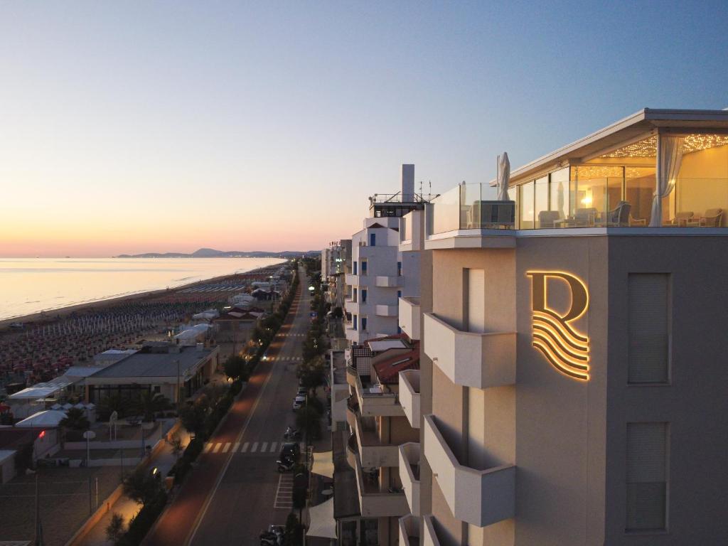 a building with the r on it next to the beach at Riviera Hotel in Senigallia