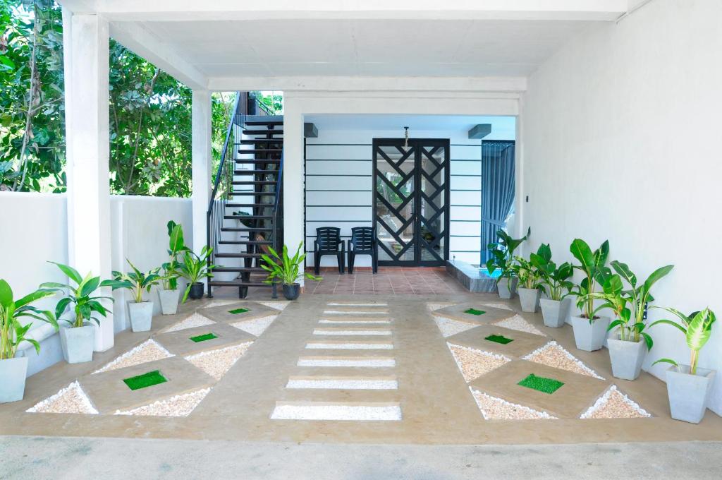 a porch with plants and a door and a staircase at Sky Haven in Matara