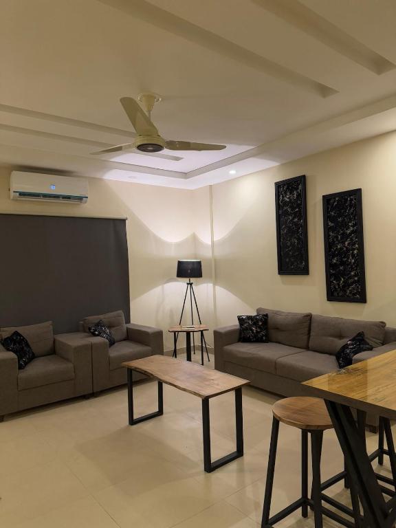 a living room with a couch and a table at The Cubee Nest- Luxury 1BHK in Central Bahria Enclave in Islamabad