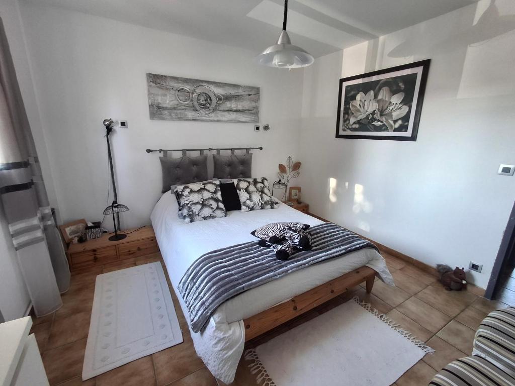 a bedroom with a bed with a black and white blanket at Grande Chambre double in Sérignan