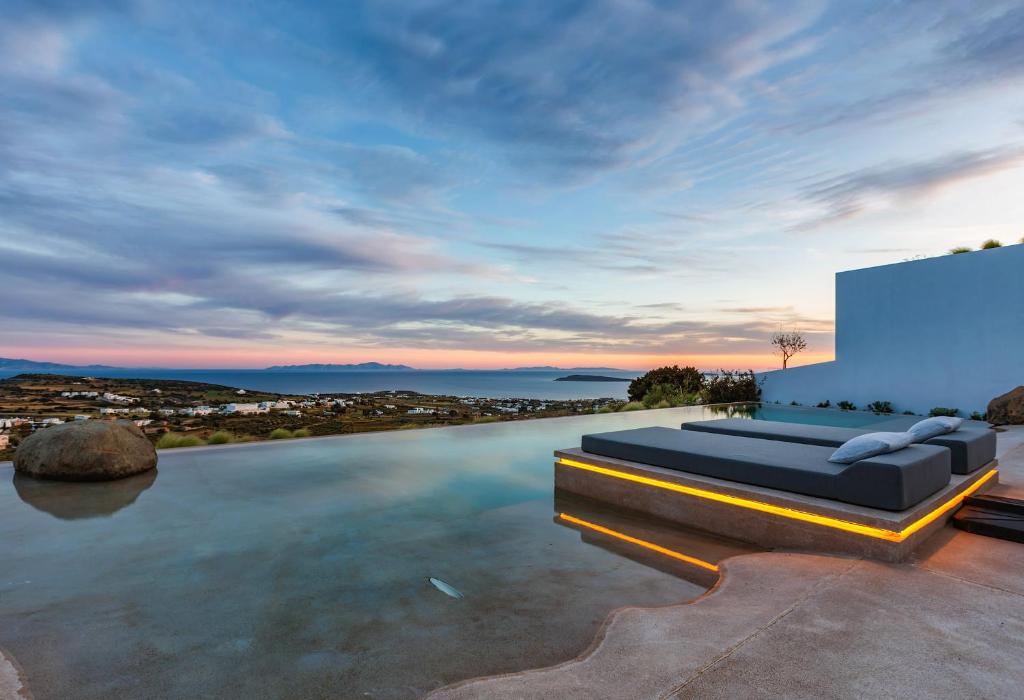 a infinity pool with a couch on the roof of a house at Skylines Estate Paros in Kampos Paros