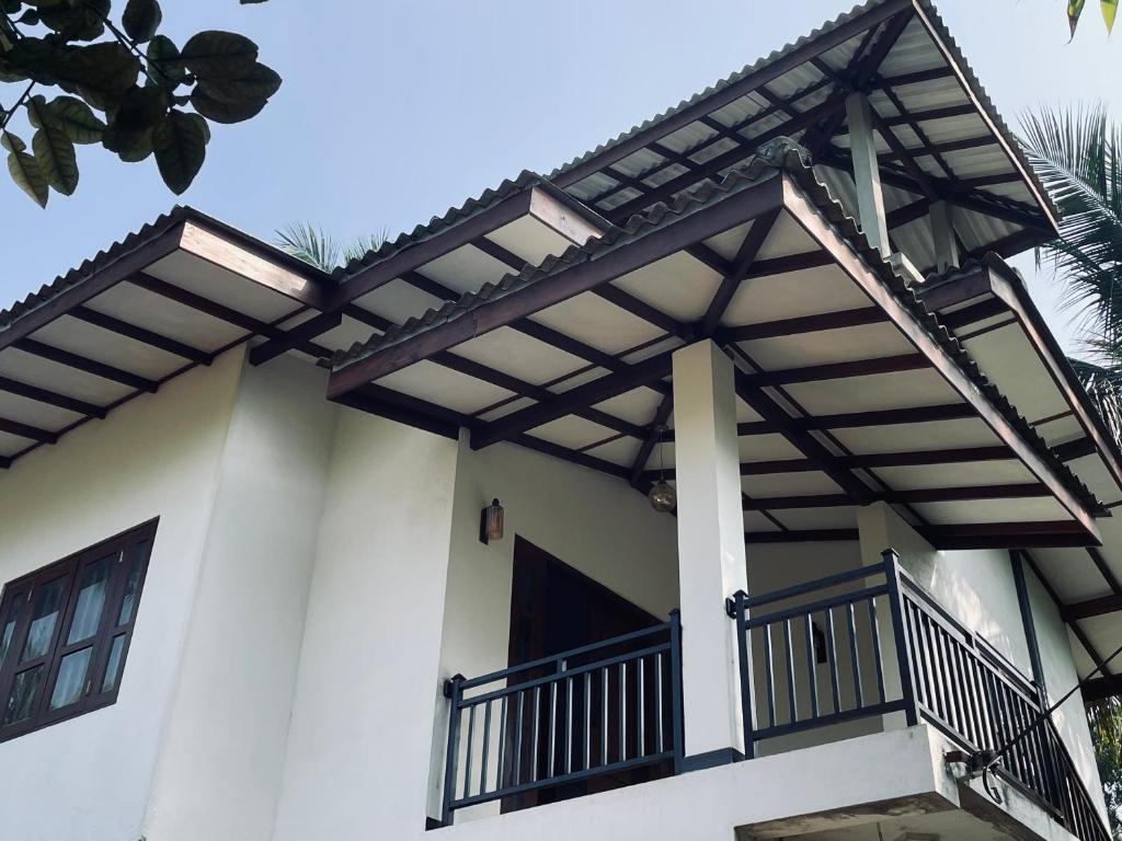 a house with awnings on the side of it at RailNest in Talpe