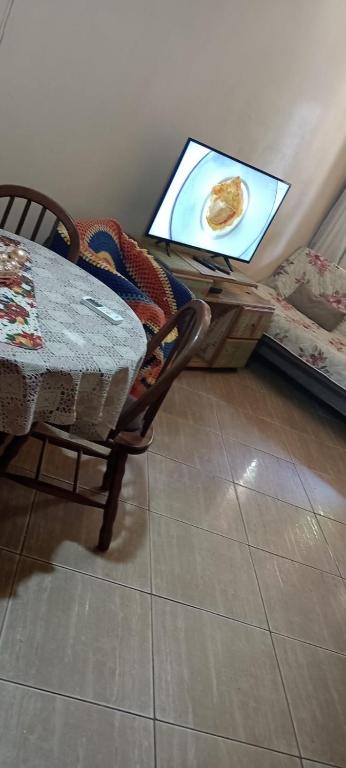 a table and chair with a plate of food on a screen at Pousada Nilda in Pântano Grande