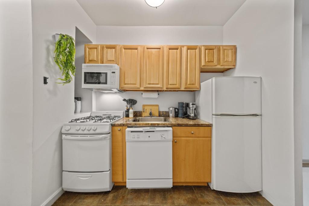 a kitchen with white appliances and wooden cabinets at Double Room with shared bathroom in Times Square in New York