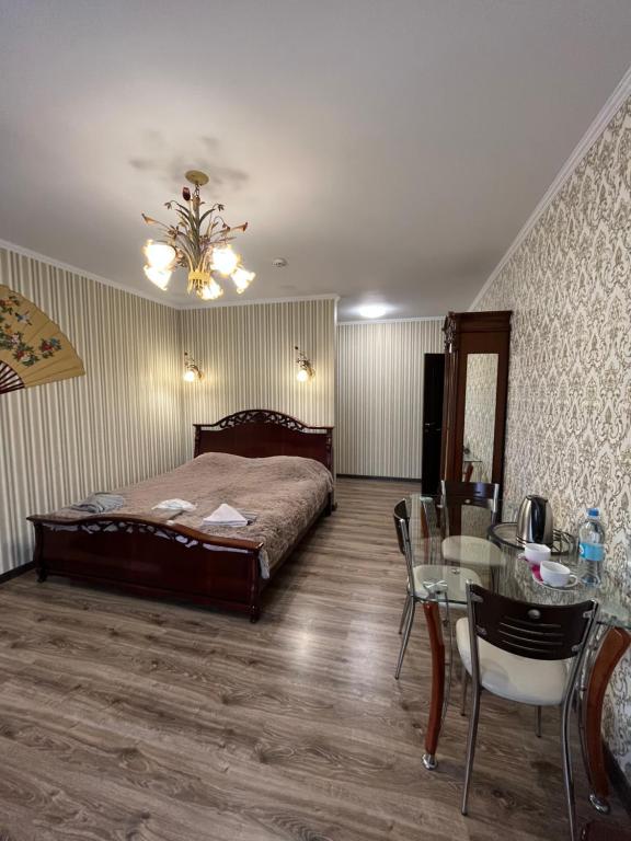 a bedroom with a bed and a table with chairs at Готель Козацький in Zvenyhorodka
