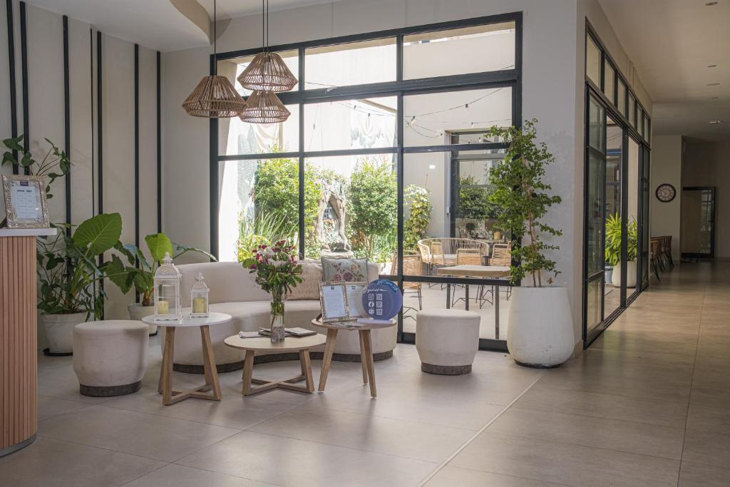 a lobby with tables and plants in a building at Hotel Caseros Salta in Salta