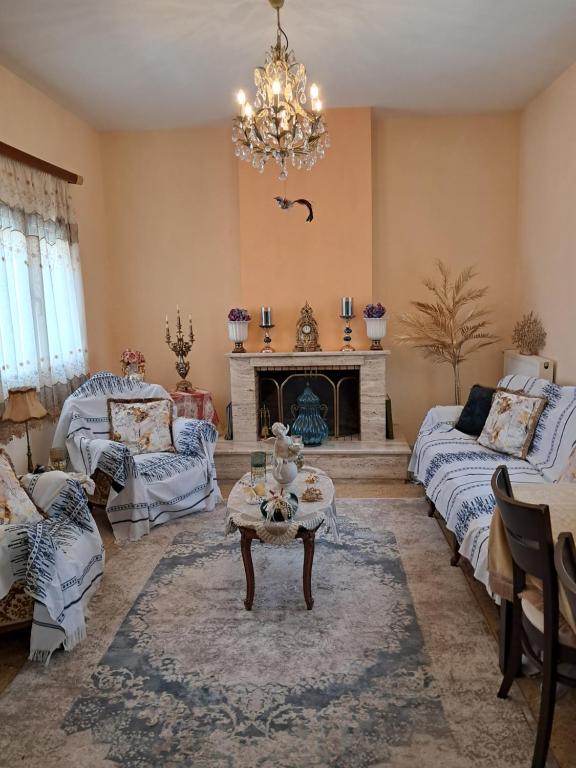 a living room with a chandelier and a fireplace at Villa Excelsior in Korinthos