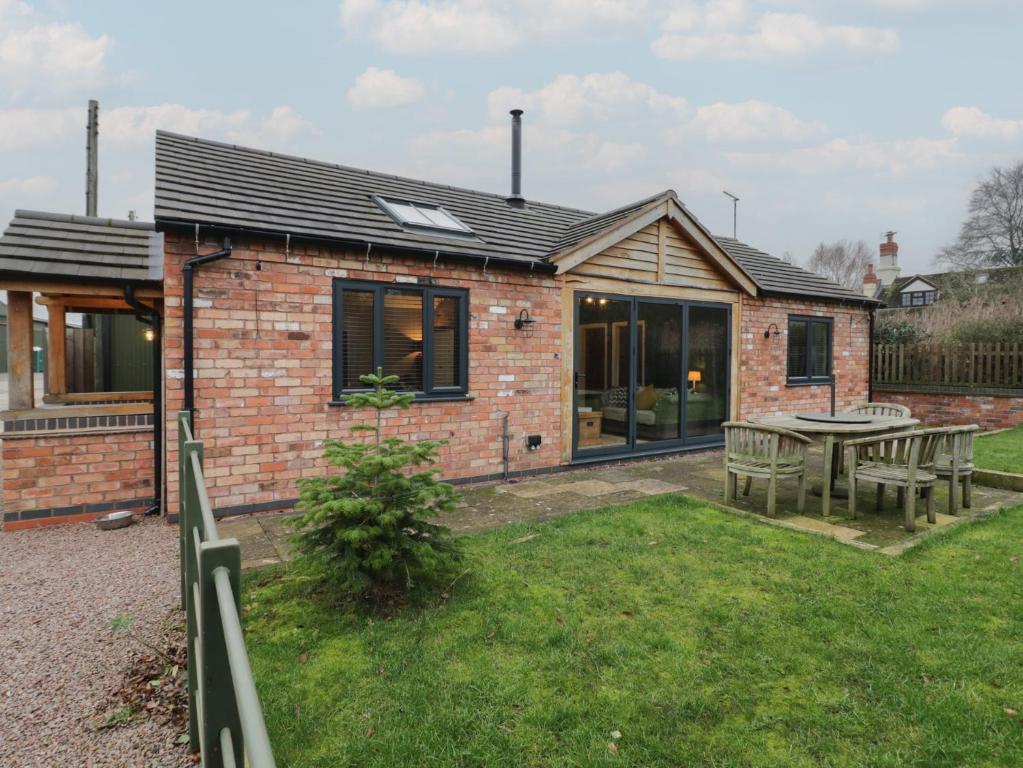 a brick house with a table in the yard at Otter's Rest in Droitwich