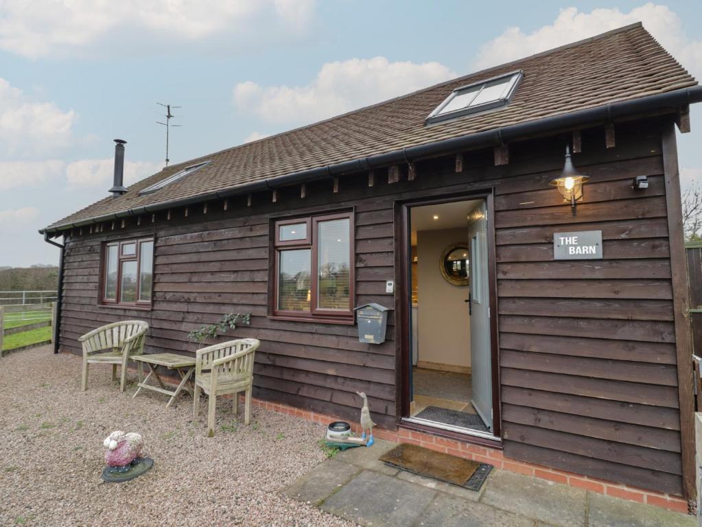a small wooden house with a table and chairs at The Barn on The Lagoon in Droitwich