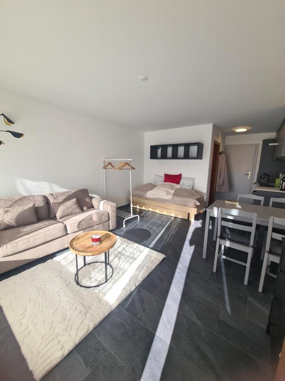 a living room with a couch and a table at Studio rénové Ovronnaz chalet Orion in Ovronnaz