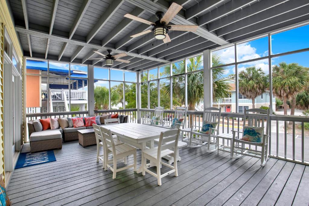 a screened in porch with a table and chairs at Front Porch Lounge in Tybee Island
