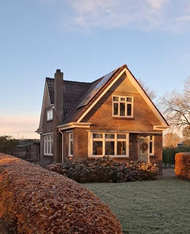 a large brick house with a large yard at Wedderhoeske in Wedde