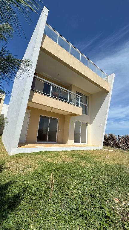 a large building with a balcony on top of a yard at Apto Areia Branca Canoa Quebrada in Canoa Quebrada