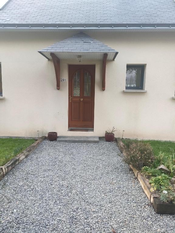 a house with a door and a gravel driveway at chambre Chez Sylvie in Allaire