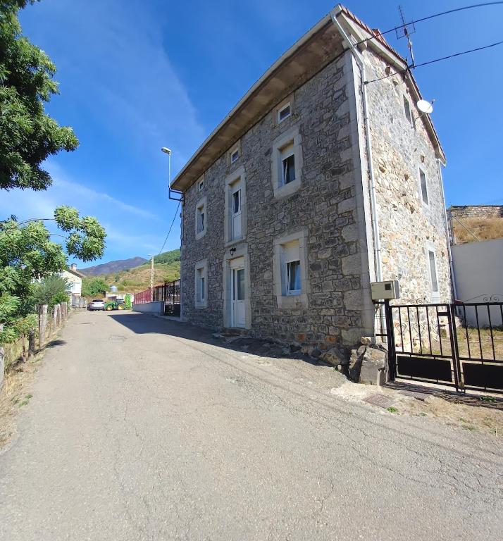 an old stone building on the side of a road at Casa Anibal in Burón
