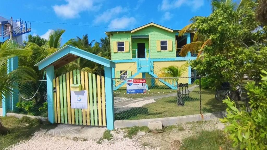 a house with a gate in front of it at SLO-N-EZ Villa- Gold Standard Certified in Caye Caulker