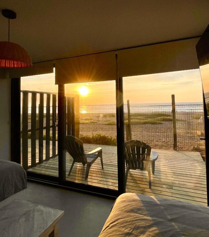 a bedroom with a bed and a balcony with a view of the ocean at Rompe Olas in Maitencillo