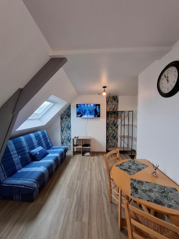 a living room with a blue couch and a table at Studio l'écluse in Le Tréport