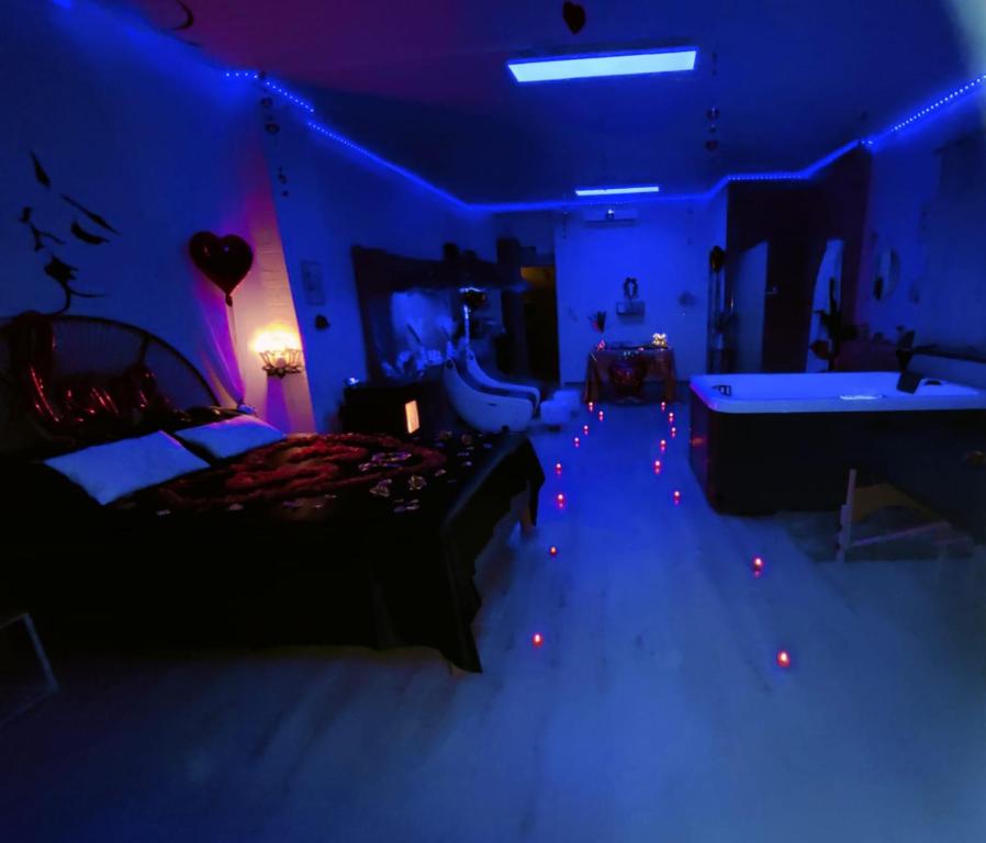 a blue room with a bed and a tub at Le relax & vous in La Louvière