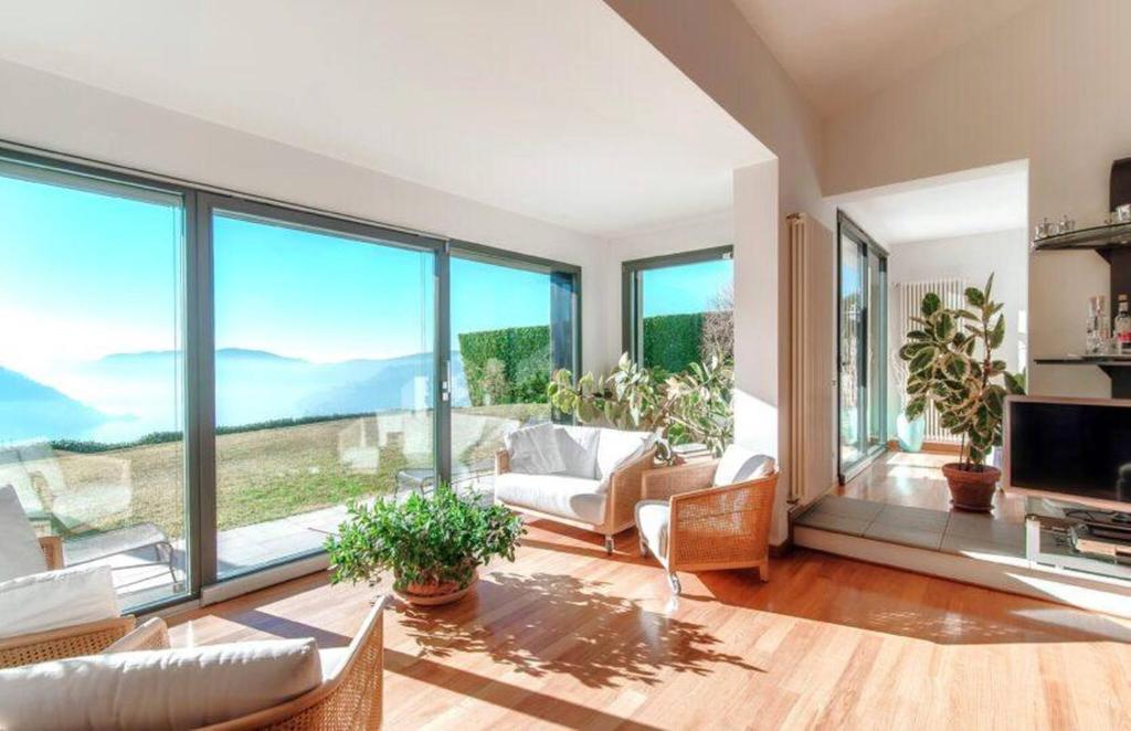 a living room filled with furniture and large windows at Villa Citriodora in Cernobbio