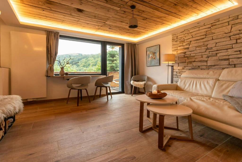 a living room with a couch and a table at Modern Birch Chalet At Ruppberg in Zella-Mehlis