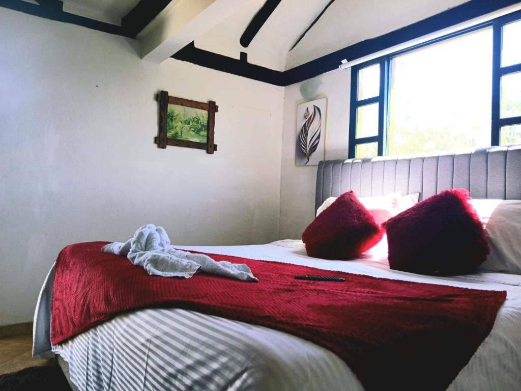 a bedroom with a large bed with red pillows at La tranquera hotel in Villa de Leyva