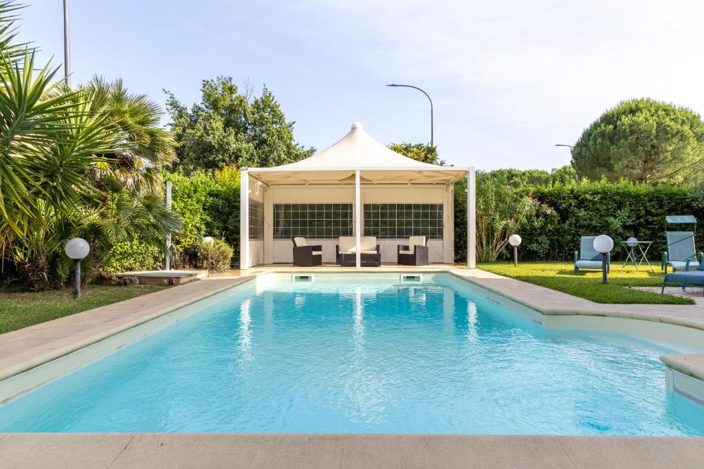a swimming pool with a gazebo in a yard at Residence Il Boschetto - Villa Con Piscina in Grosseto