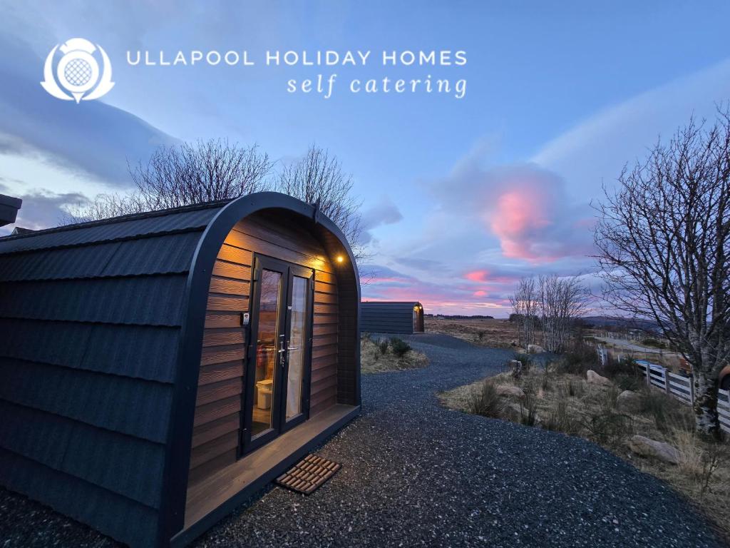 a tiny house on a gravel road with the sunset at Rowan Gorgeous Glamping Hideaway in Durnamuck