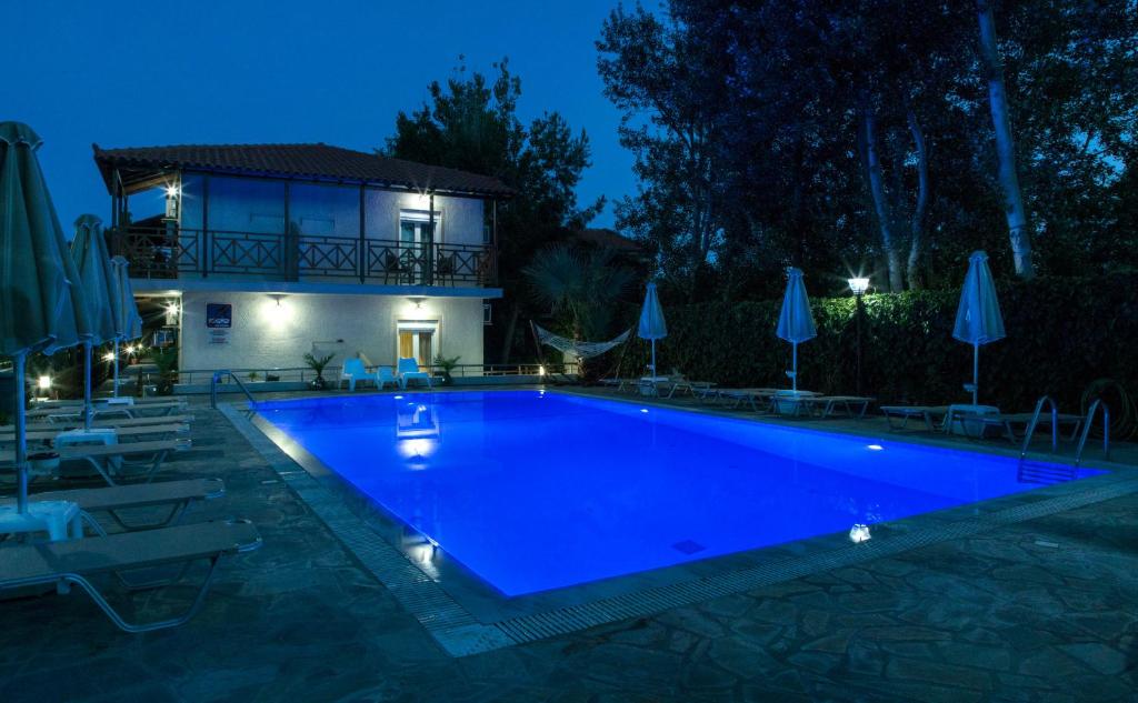 una piscina di fronte a una casa di notte di Studio Nikos a Pythagóreion