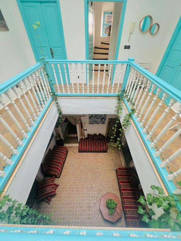 a staircase with red cushioned chairs in a house at Riad darkoum in Essaouira
