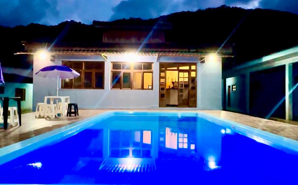 a swimming pool in front of a house at night at Pousada Almeida in Iguape
