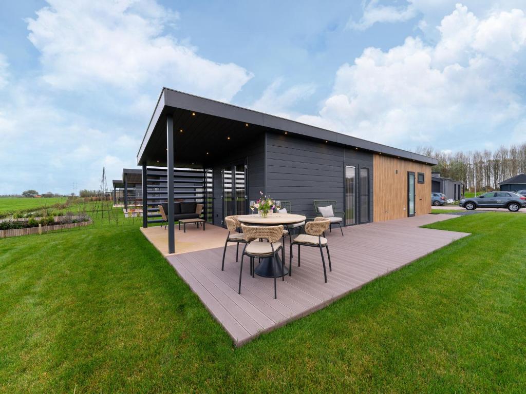a patio with a table and chairs in a yard at Bij de Bakker in Oud-Ade