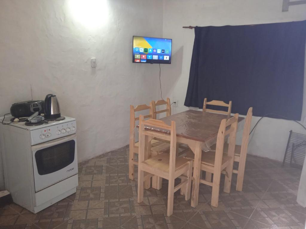 a kitchen with a table and chairs and a stove at Los Cali 27 planta alta 1 in Balneario Buenos Aires
