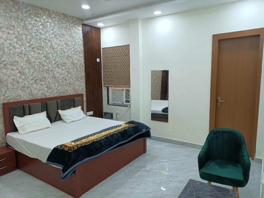 a bedroom with a bed and a green chair at Kamadgiri Green Valley in Nawābganj