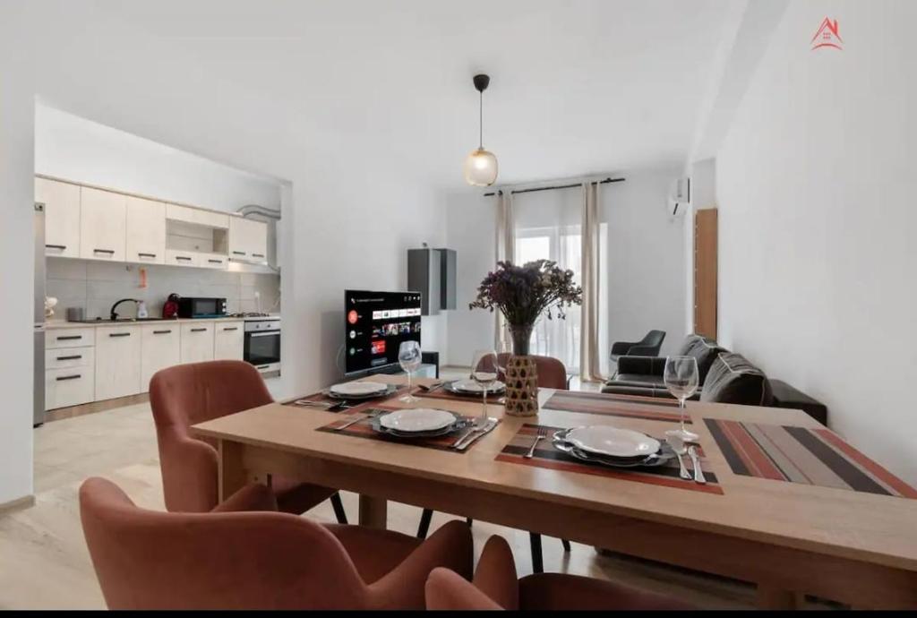 a kitchen and dining room with a table and chairs at Apartament 2 dormitoare spatios, Aer conditionat, Flat Screen TV, Self Check-in in Ştefăneştii de Sus