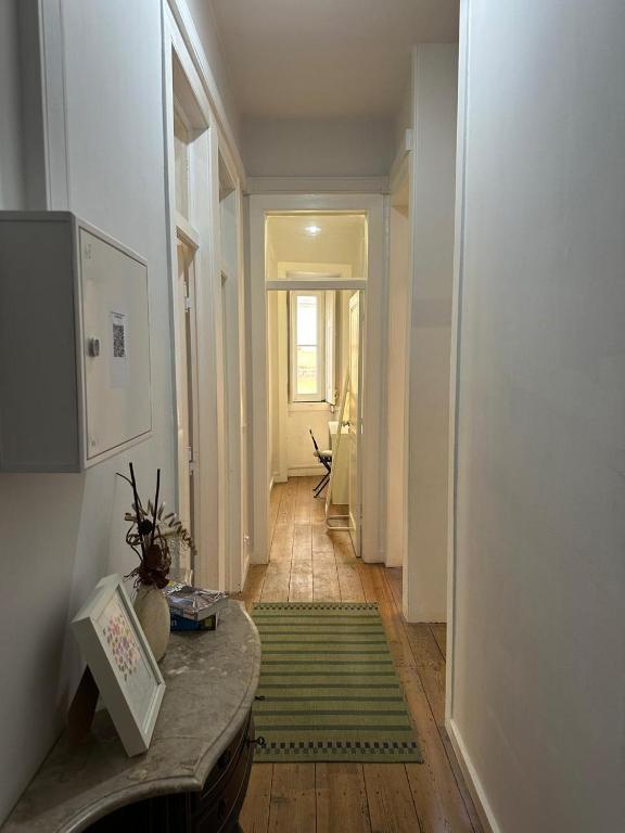 a hallway with a table and a green rug at Sintra Flower Camelia Apartment in Sintra