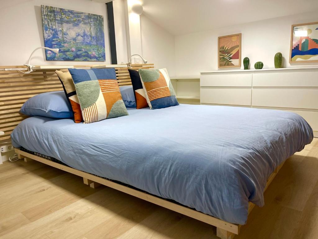 a bedroom with a bed with blue sheets and pillows at Capitole Hyper-centre, Mezzanine & confort in Toulouse