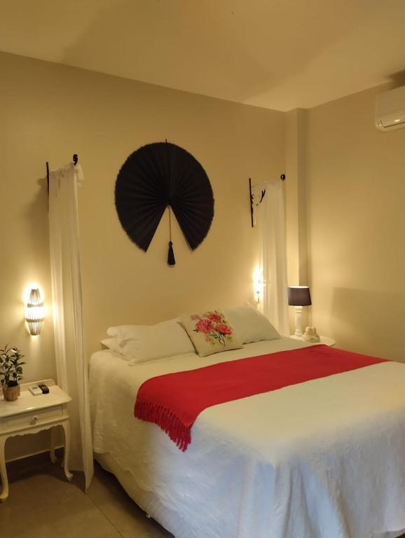 a bedroom with a large bed with an umbrella on the wall at Casa das Flores Bistrô e Pousada in Taquarussu Tocantins