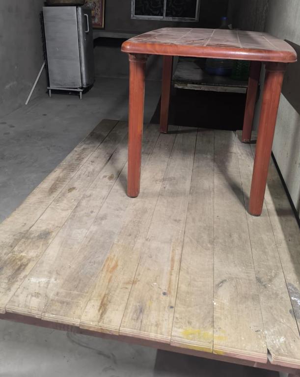 a wooden table sitting on top of a wooden floor at dormatery rooms in Jāmb