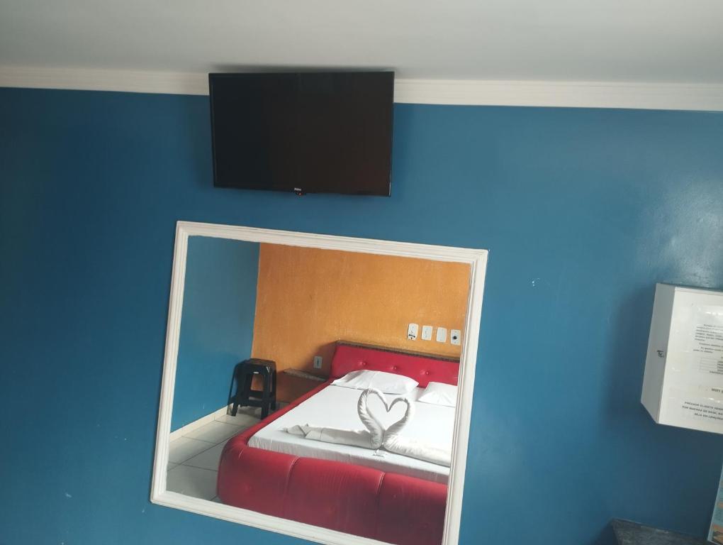 a mirror in a room with a bed with two hearts at Motel pousada Zafira in Salvador