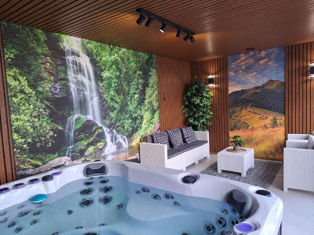 a bath tub in a room with a waterfall mural at Agroturystyka Gazdówka in Zakliczyn