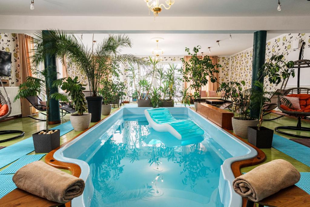 a pool in a hotel with plants at Rezydencja Florina - Willa z prywatnym basenem, jacuzzi i kortem tenisowym in Rogóźno