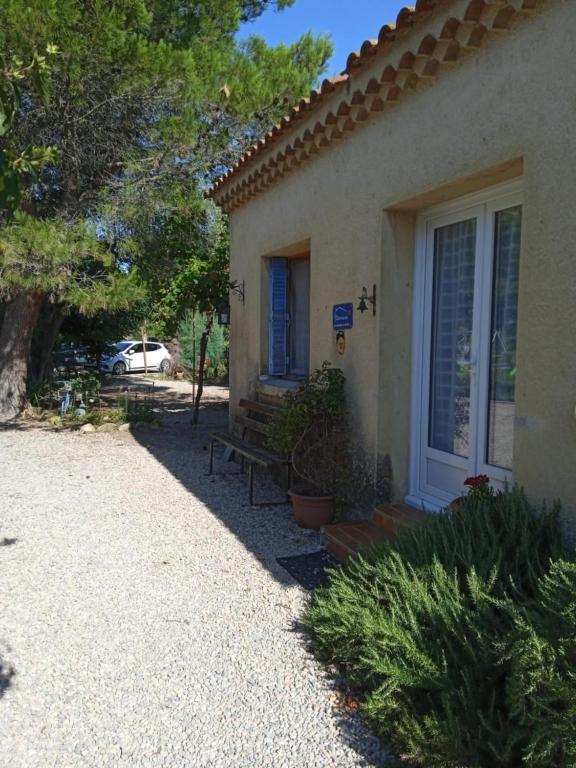 a house with a bench in front of it at La barque aux Romarins in Orange