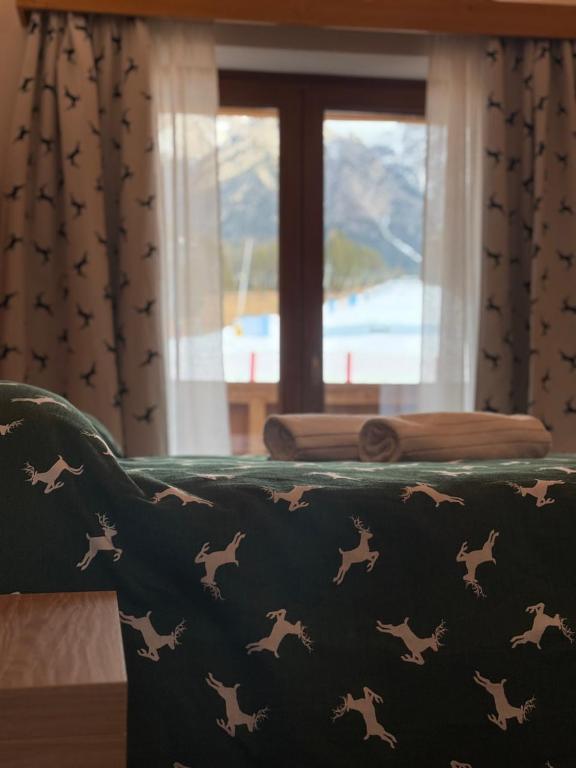 a couch with a blanket with horses on it at Locanda Baita Donariè in San Vito di Cadore
